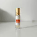 Small glass oud perfume oil bottle with gold cap on white background