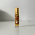 Amber oud perfume oil bottle with gold cap on white background, Islamic fragrance.