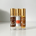Three glass perfume bottles with gold caps labeled Al Oud, Musk Blanc, and Anbar on white background.