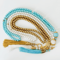 Islamic prayer beads with gold, white, and turquoise strands and decorative tassels