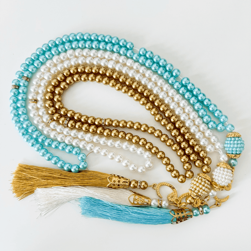 Islamic prayer beads with gold, white, and turquoise strands and decorative tassels
