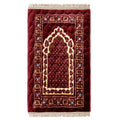 Red Islamic prayer mat with intricate gold and blue geometric patterns on white background