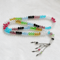 Islamic tasbih prayer beads with multicolor glass beads and silver tassels on white background